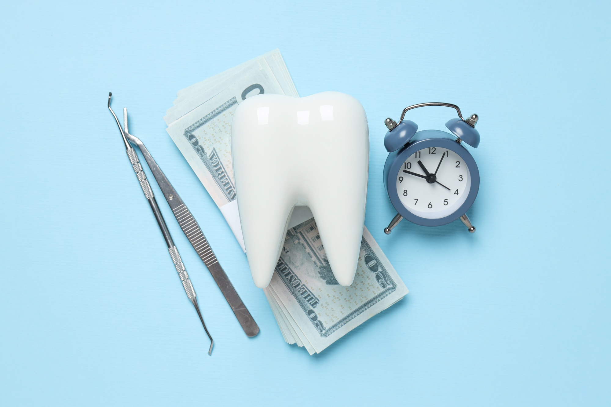 Dental cost concept with a tooth, money and dental tools