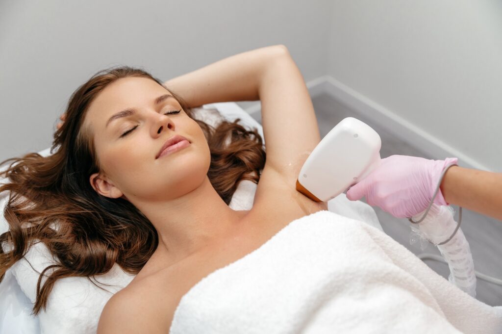 Beauty procedure. Hair removal by laser hair removal. Caucasian young woman lies on the couch with