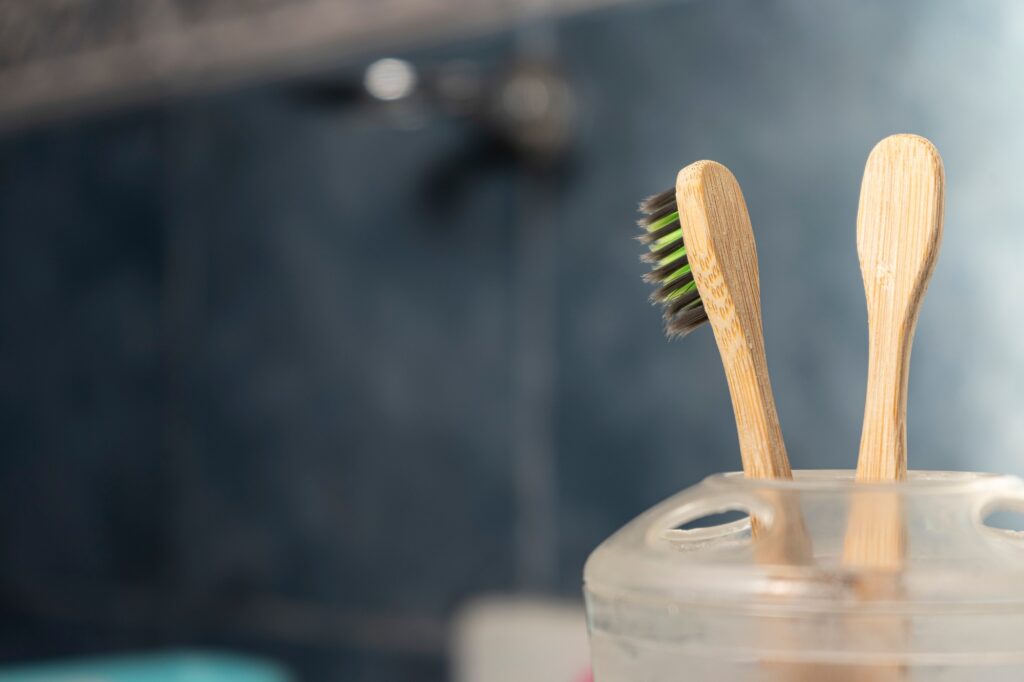 Bamboo toothbrushes in a toothbrush cup in a light blue bathroom