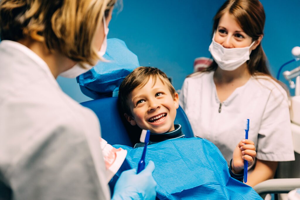 Doctor dentist teaching a child to brush teeth.