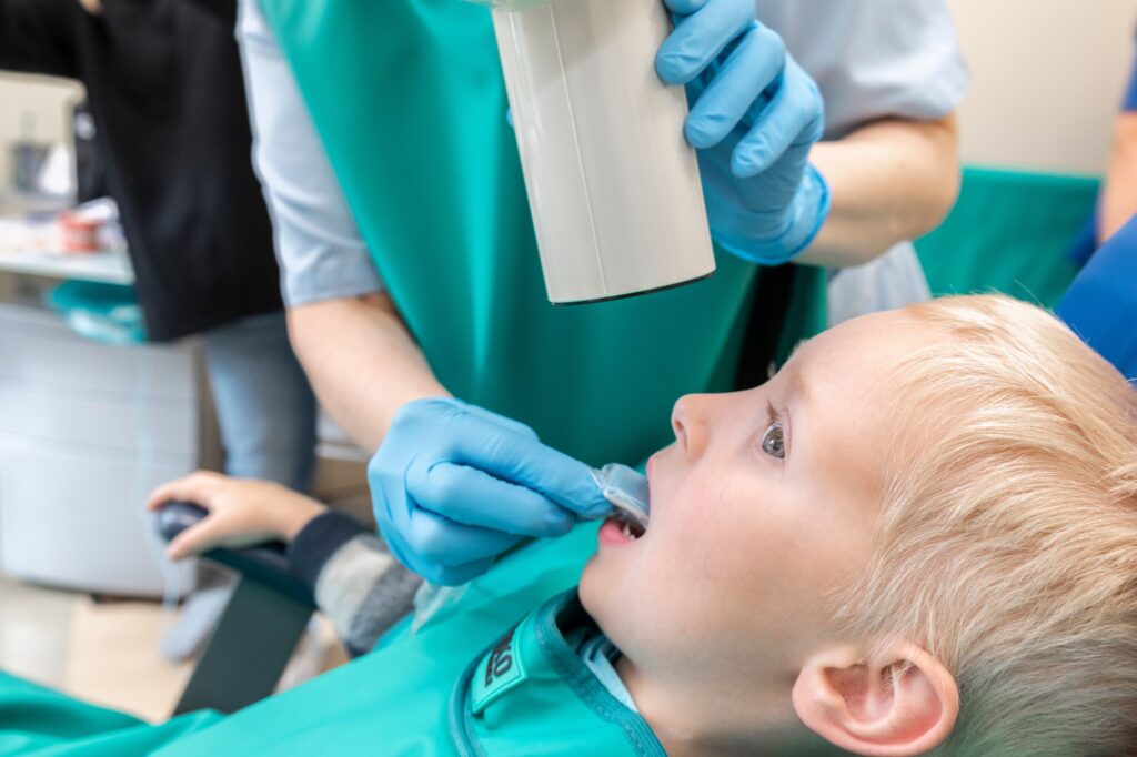 Little boy at dentist's office. Doctor makes kid x-ray of tooth
