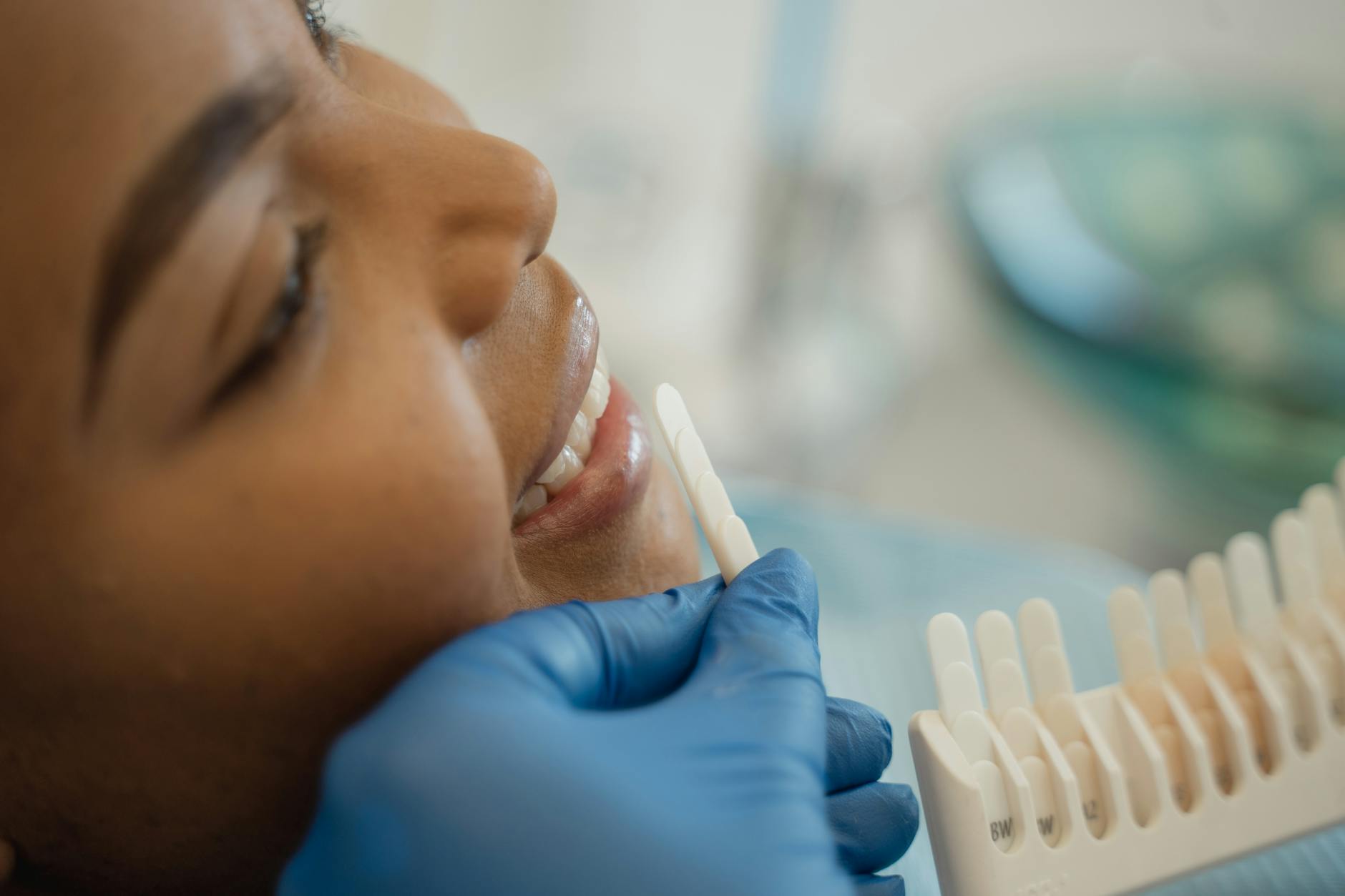 dentist examining patient's teeth shade guide