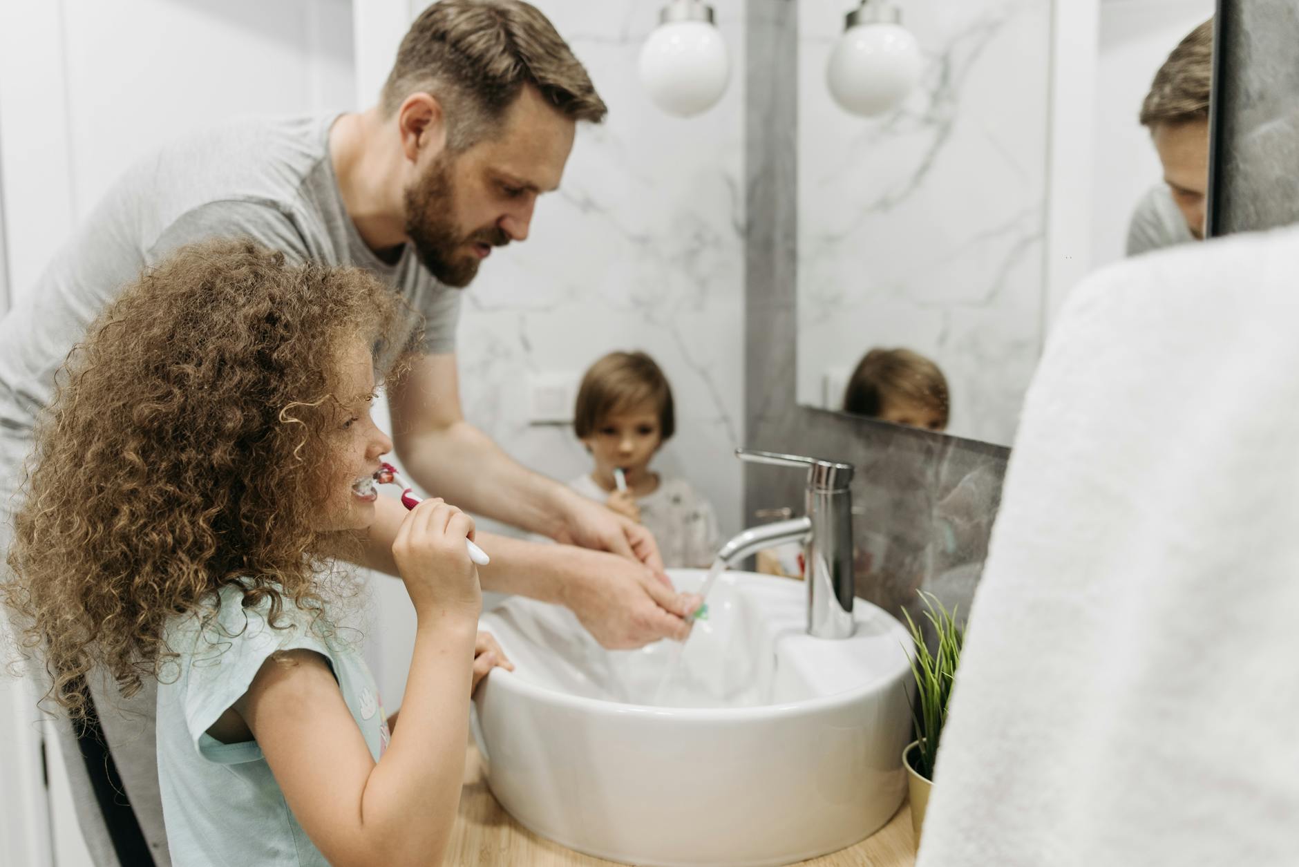 family of four brushing teeth together at home