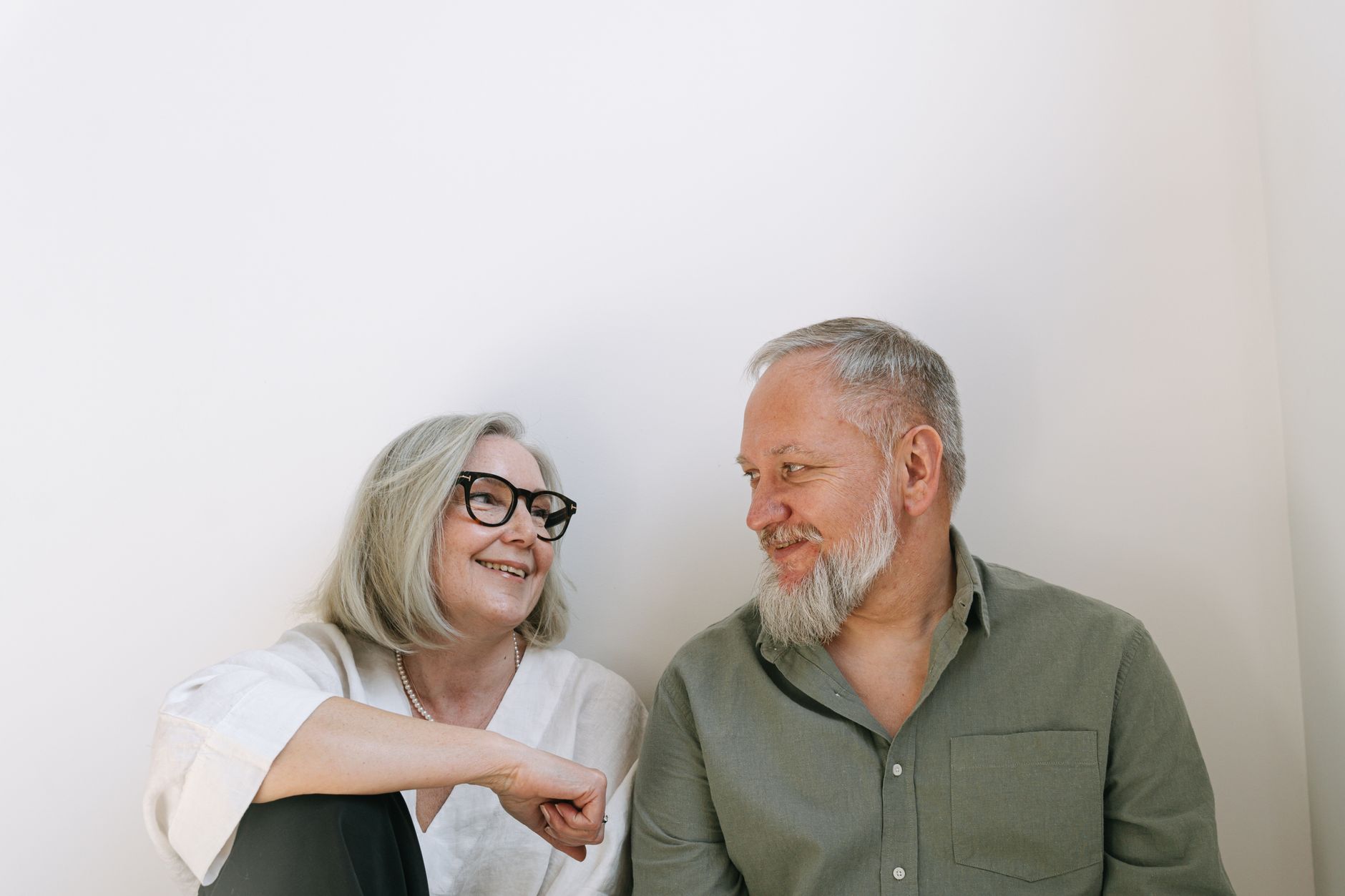 mature professional couple laughing together showing perfect smiles