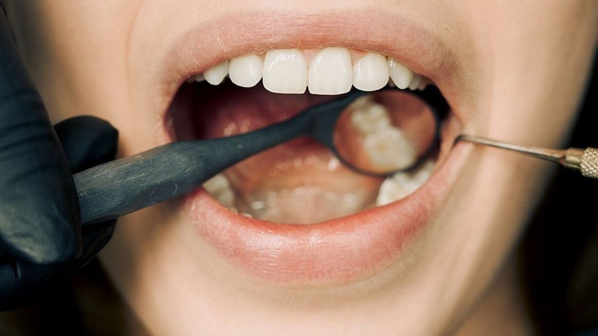 Dentist checking a tooth closely with a hand instrument