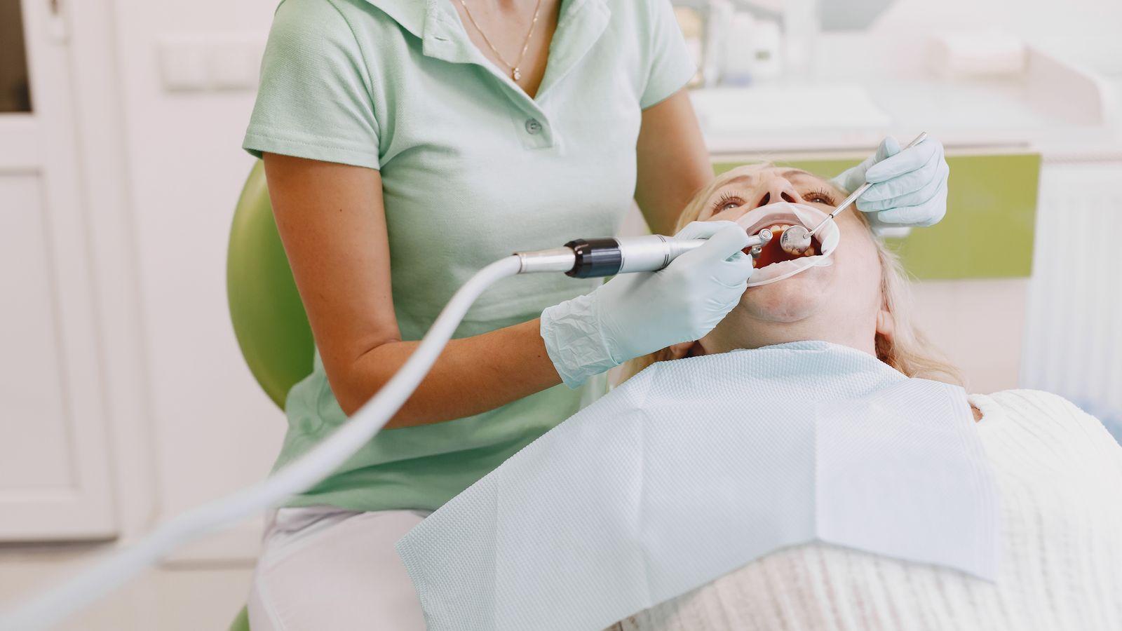 Dental hygienist examining a patient during a cleaning appointment
