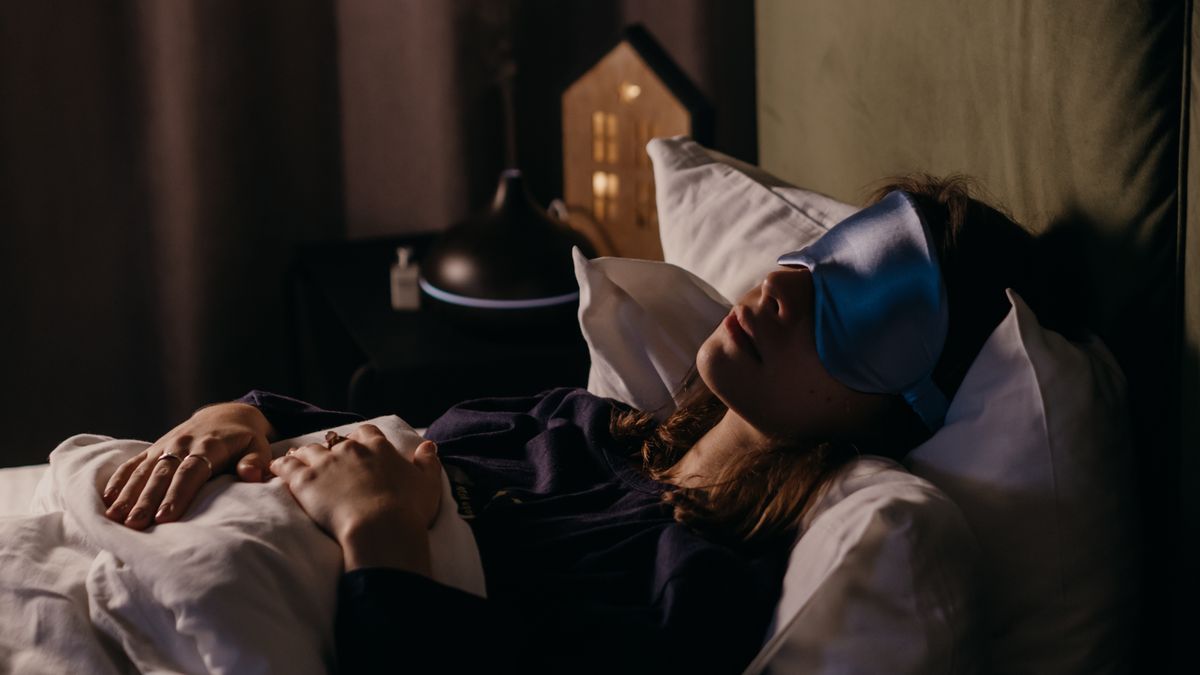 Person asleep in a dark bedroom at night