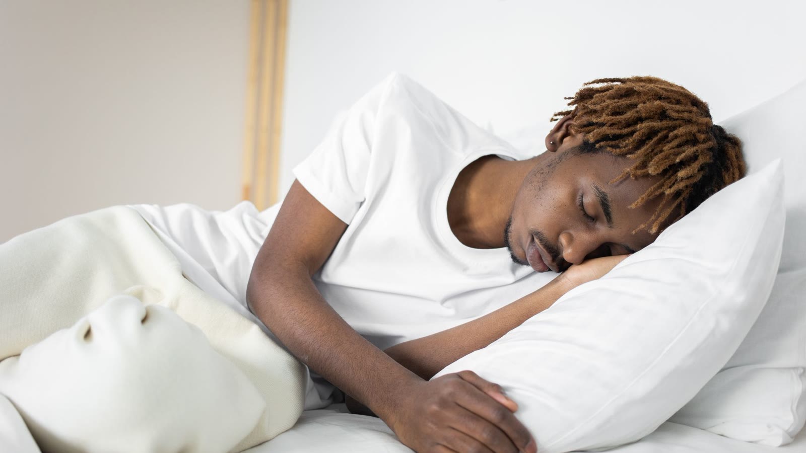 Man sleeping on his side on a white pillow