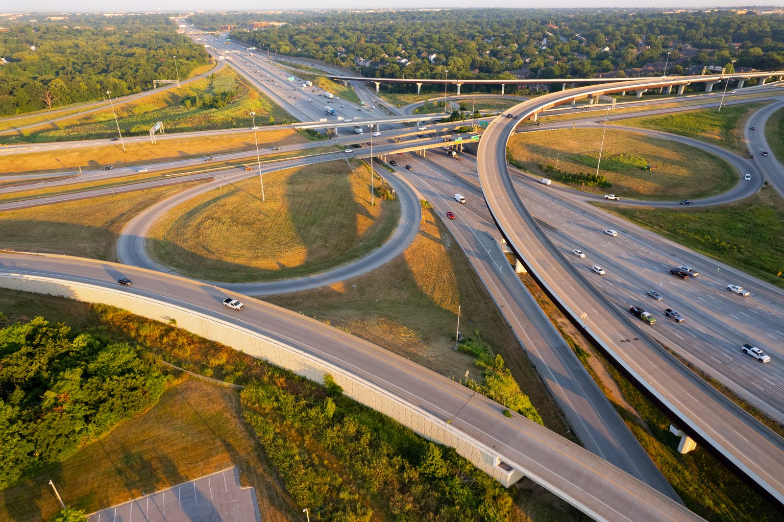 Stunning aerial shot of a highway interchange in Overland Park, Kansas during golden hour, showcasing intricate road networks