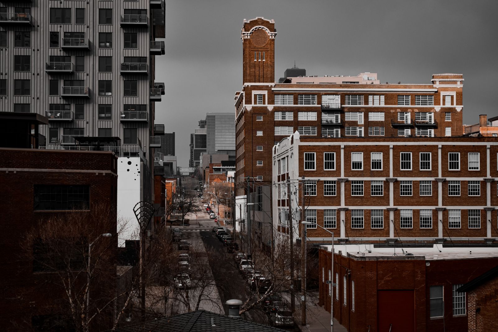 Explore the dense urban landscape of Kansas City, featuring historic brick architecture and modern apartment buildings on a cloudy