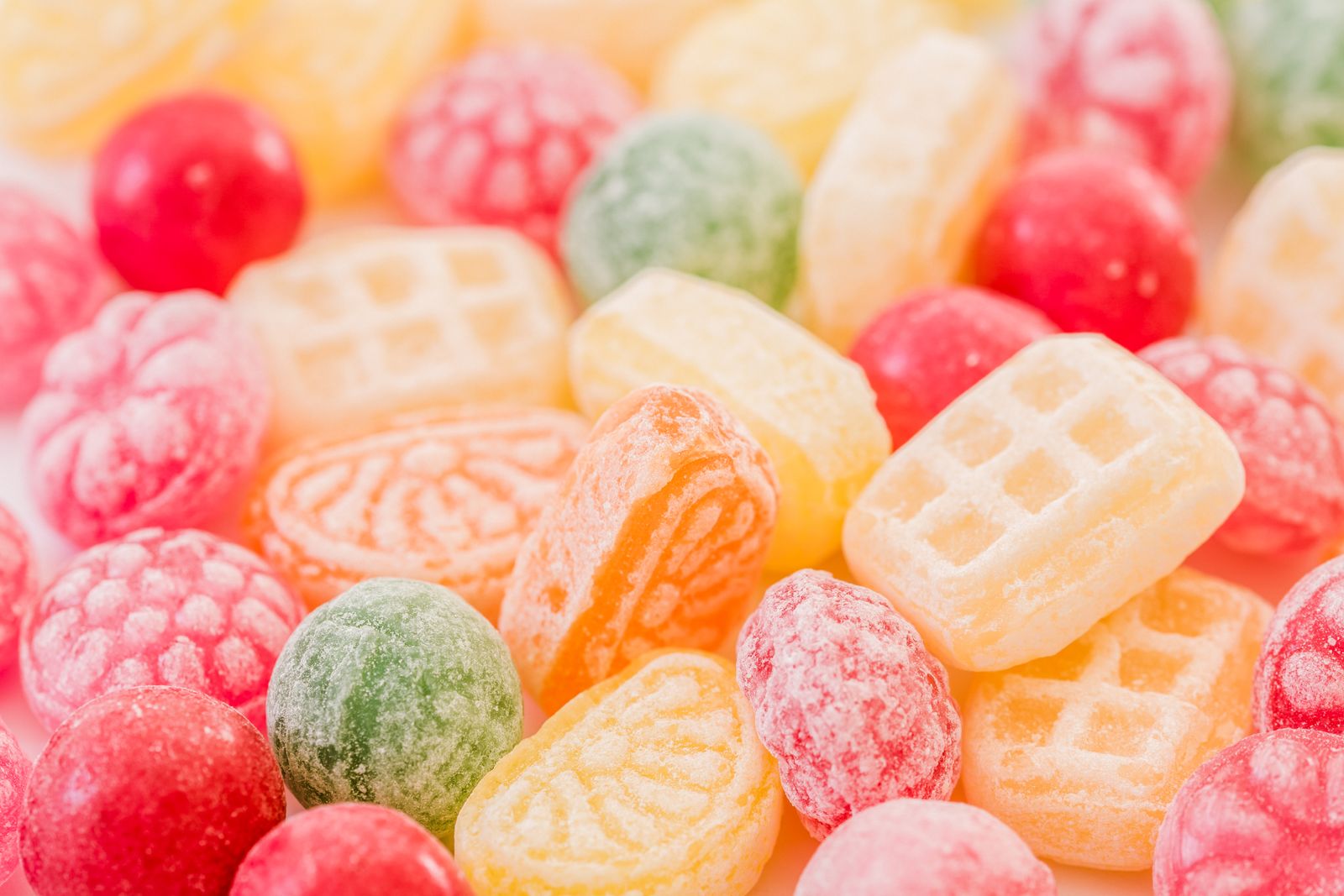 A close-up view of assorted colorful hard candies with various shapes and colors