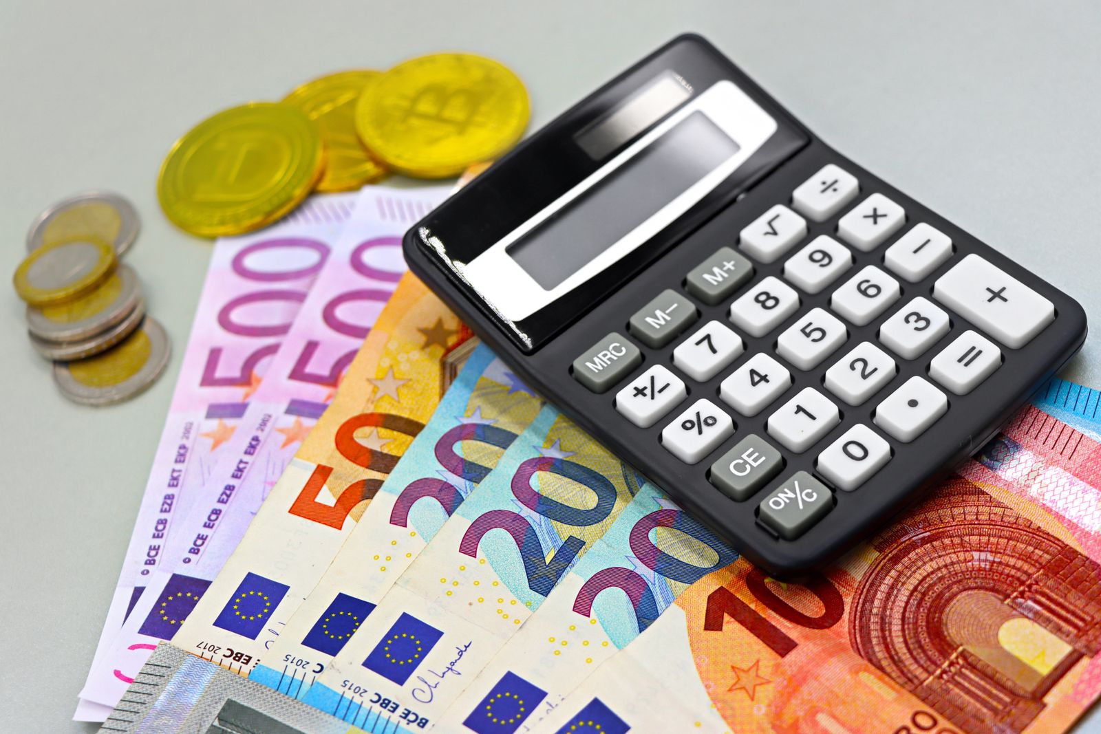 Image of euro banknotes, coins, and a calculator for financial planning. Perfect for finance themes