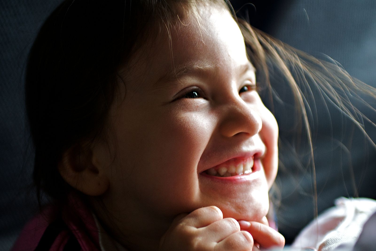 Close-up of a smiling young girl with joyful expression, capturing happiness and innocence indoors