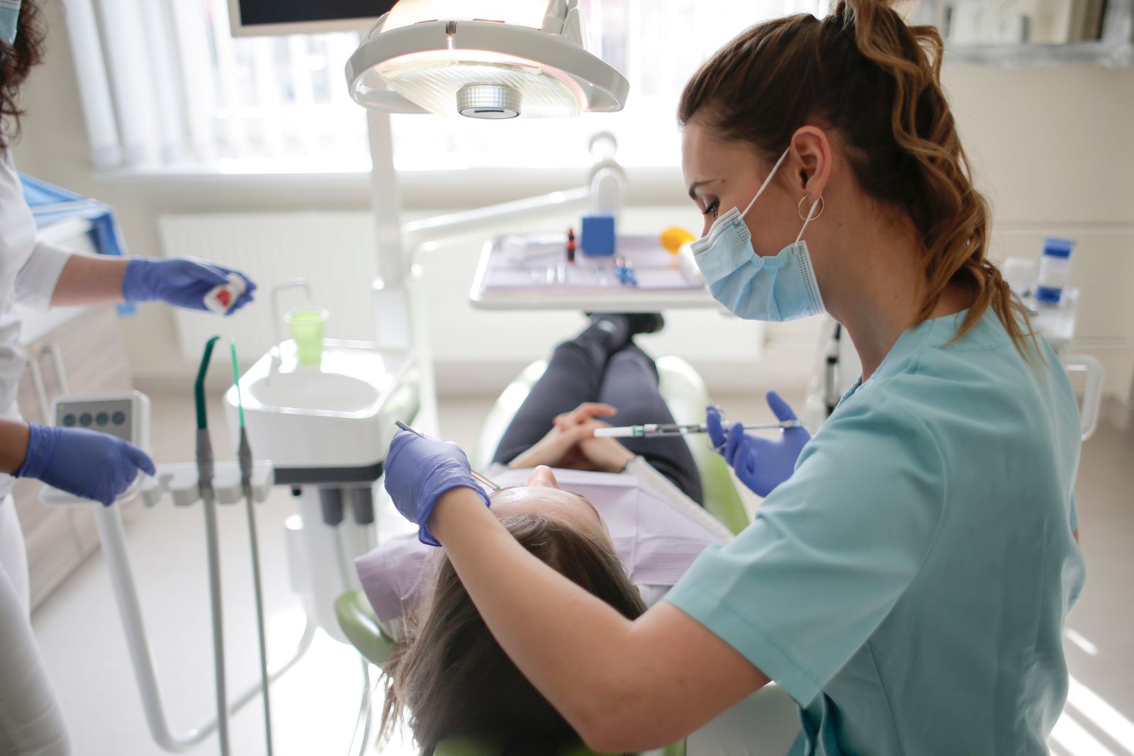A female dentist performs dental treatment on a patient in a modern clinic