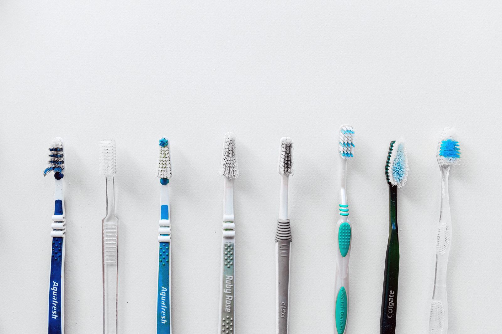 Diverse selection of toothbrushes lined up for dental hygiene focus with copy space