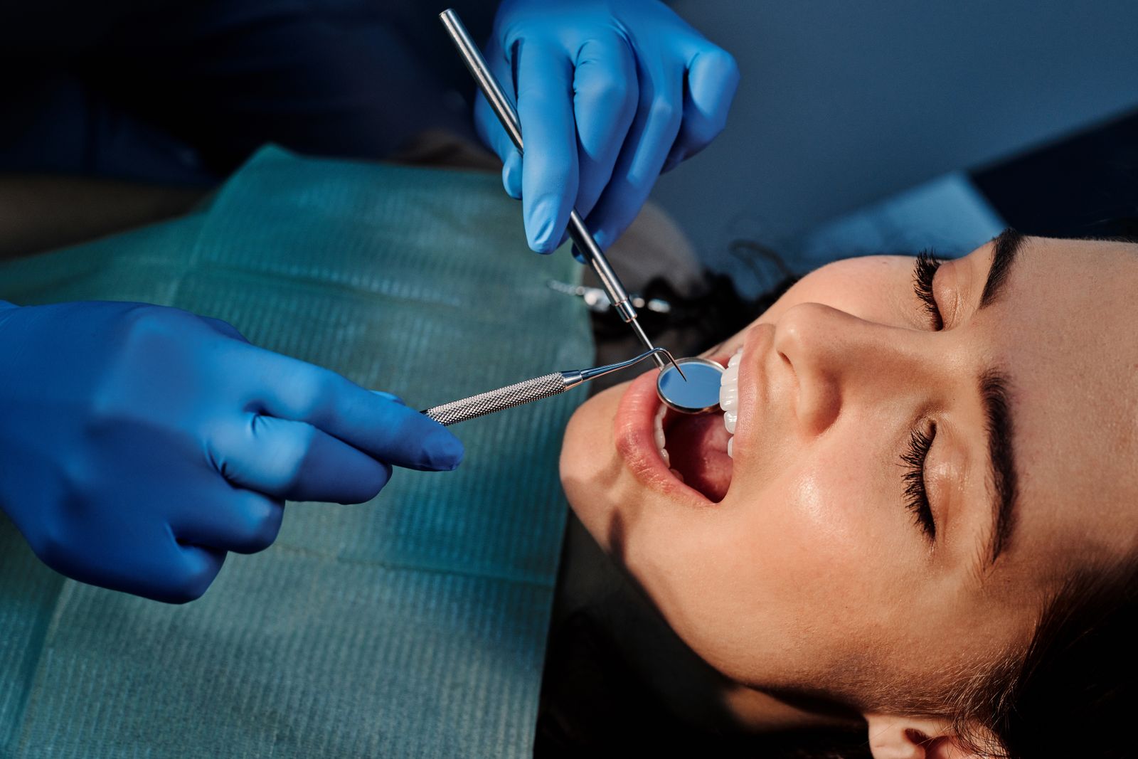 Close-up of a dentist examining a patient's teeth using dental tools