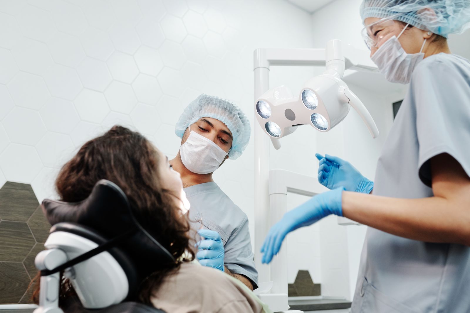 Dentists in a clinic performing a routine checkup on a patient with professional dental equipment
