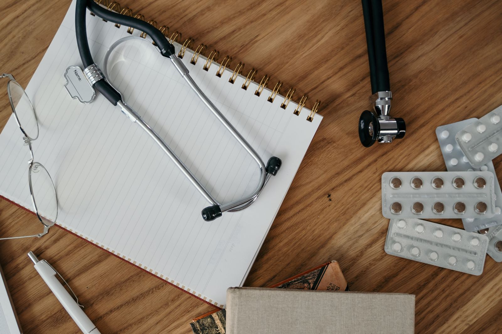 Flat lay of medical tools and supplies on a wooden desk surface