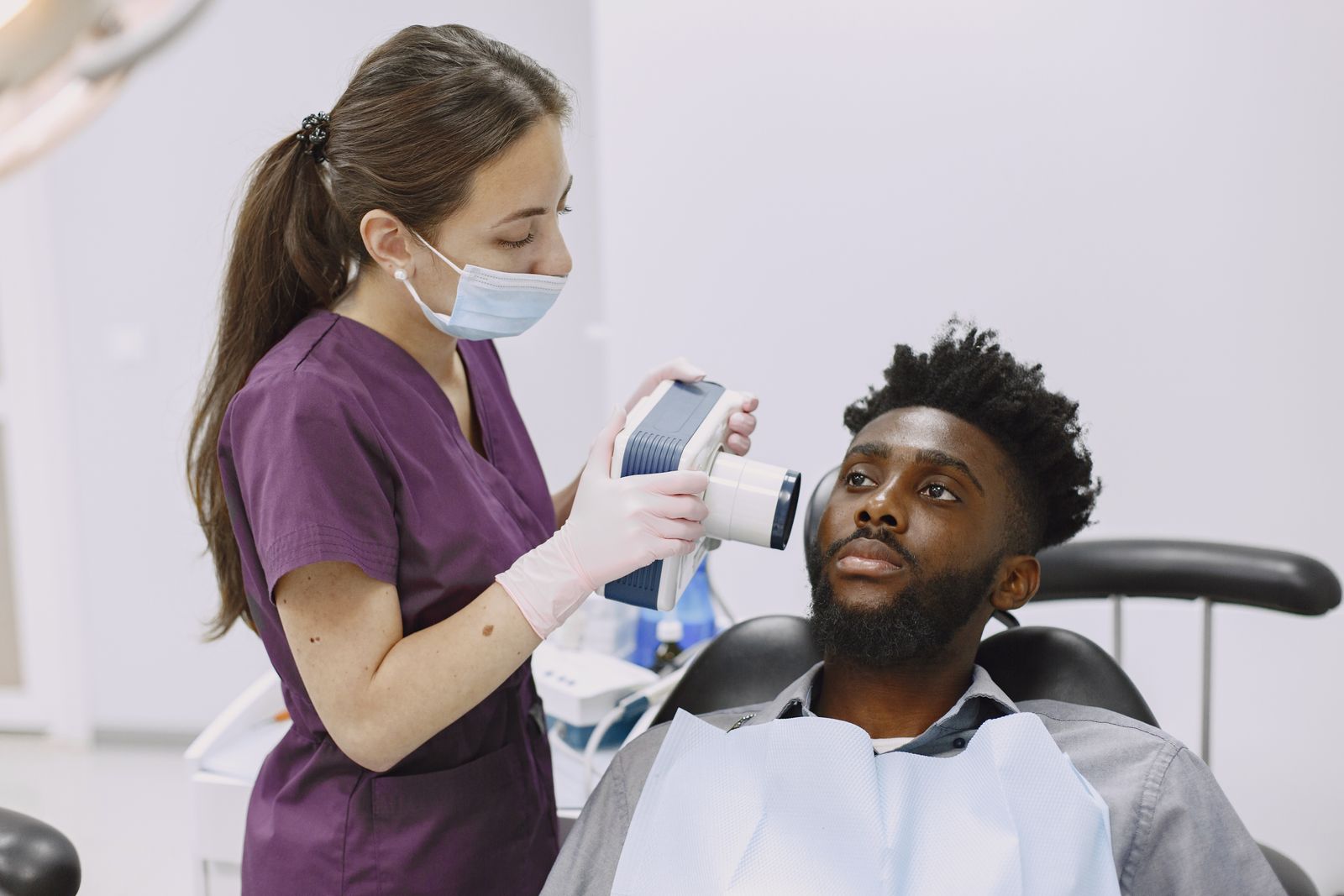 A dentist performing a dental x-ray on a patient using modern equipment in a clinic