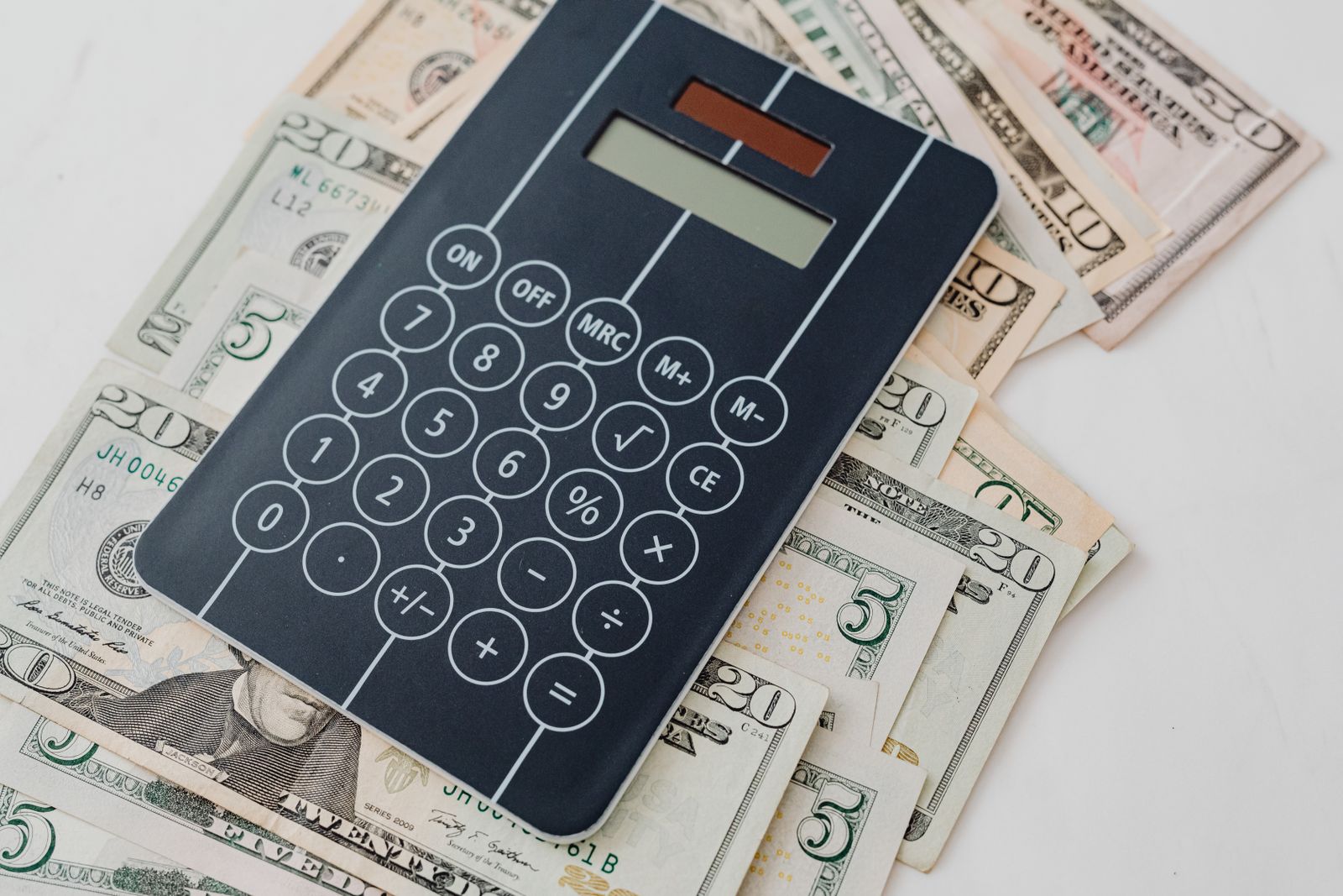 Close-up of a calculator atop US dollar bills, symbolizing financial planning and budgeting