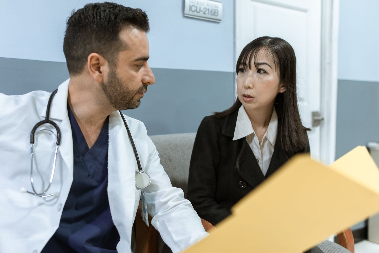A doctor consults with a colleague in a hospital, examining medical documents