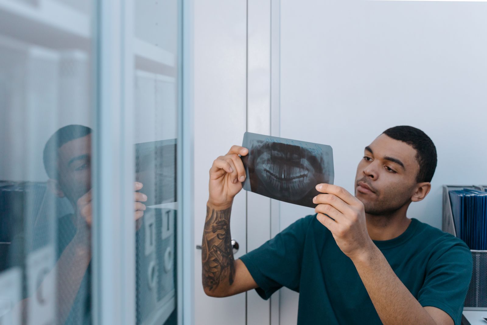Young dentist examining a dental X-ray in a clinic setting. Professional healthcare practice