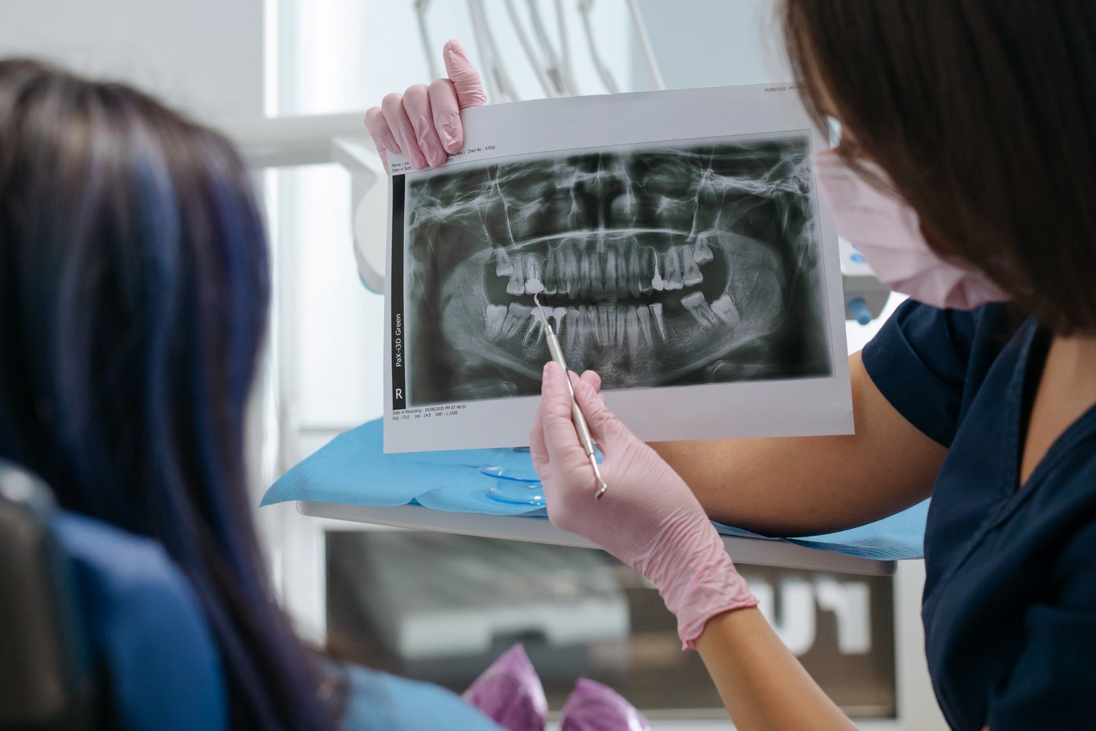 A dentist showing a dental X-ray to a patient, explaining the results and treatment options