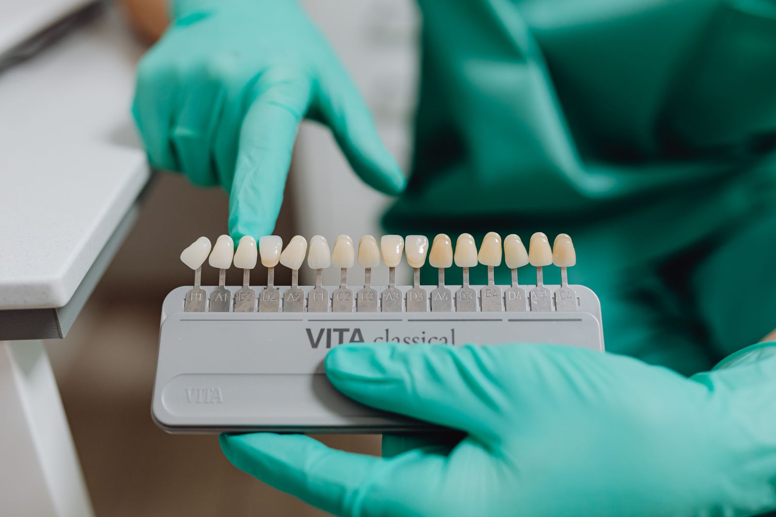 Close-up of dentist using a tooth shade guide for accurate dental matching in clinic