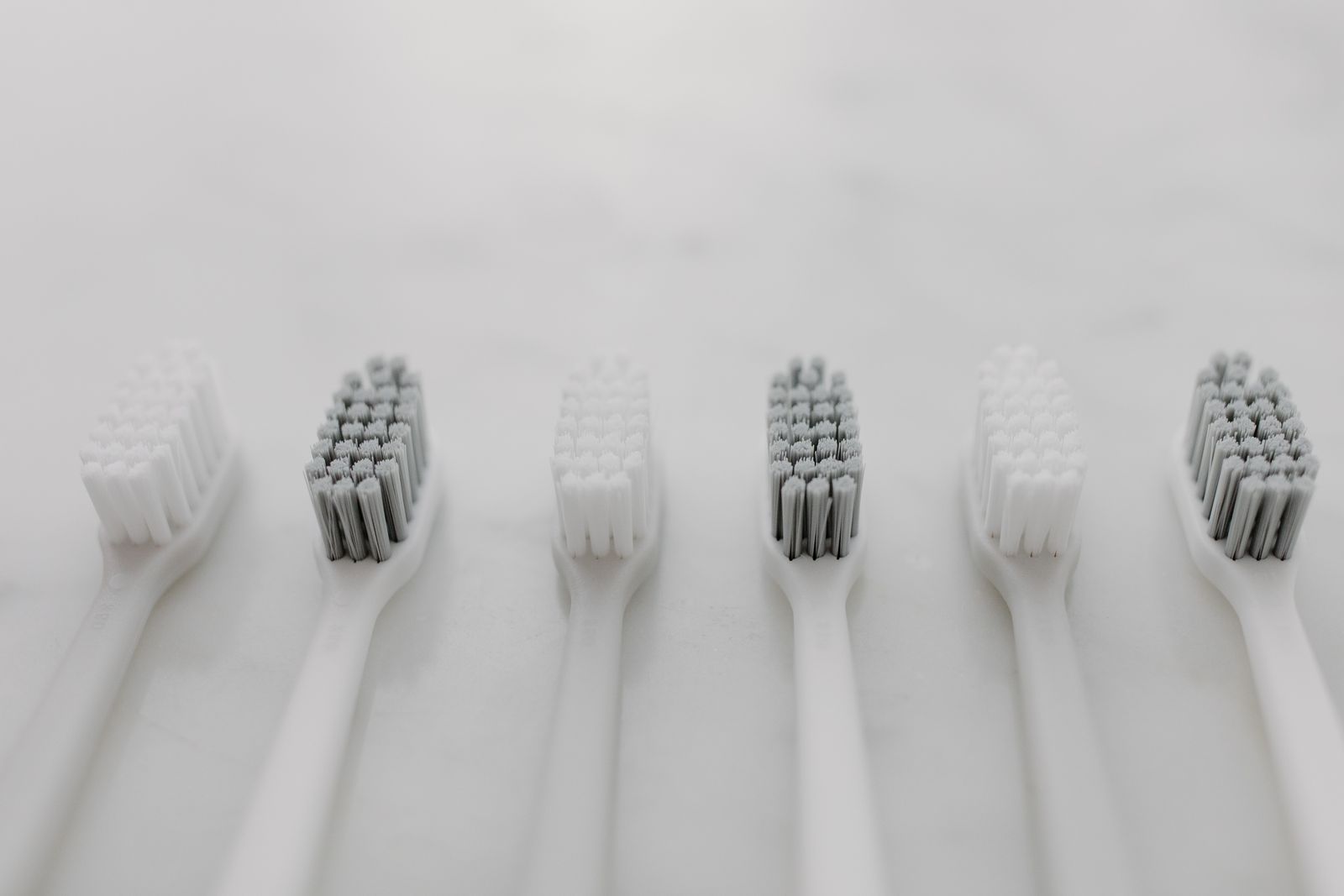 A clean and minimalist flat lay of toothbrushes on a marble surface for oral hygiene