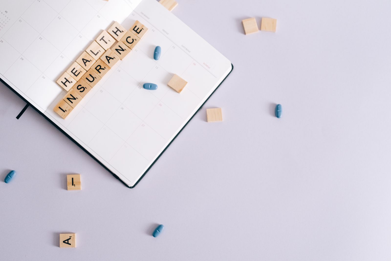 Flat lay of health insurance concept with planner and pills