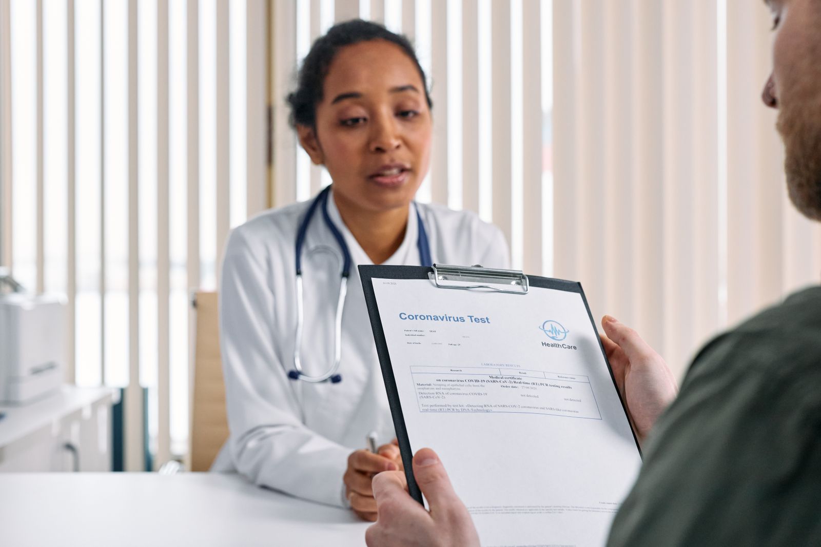 Doctor having a consultation with a patient over coronavirus test results in a medical office