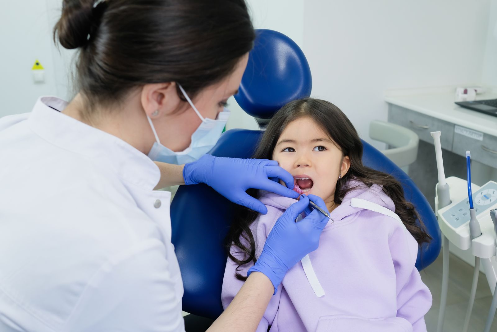 Young girl receives dental checkup from a female dentist in a clinic