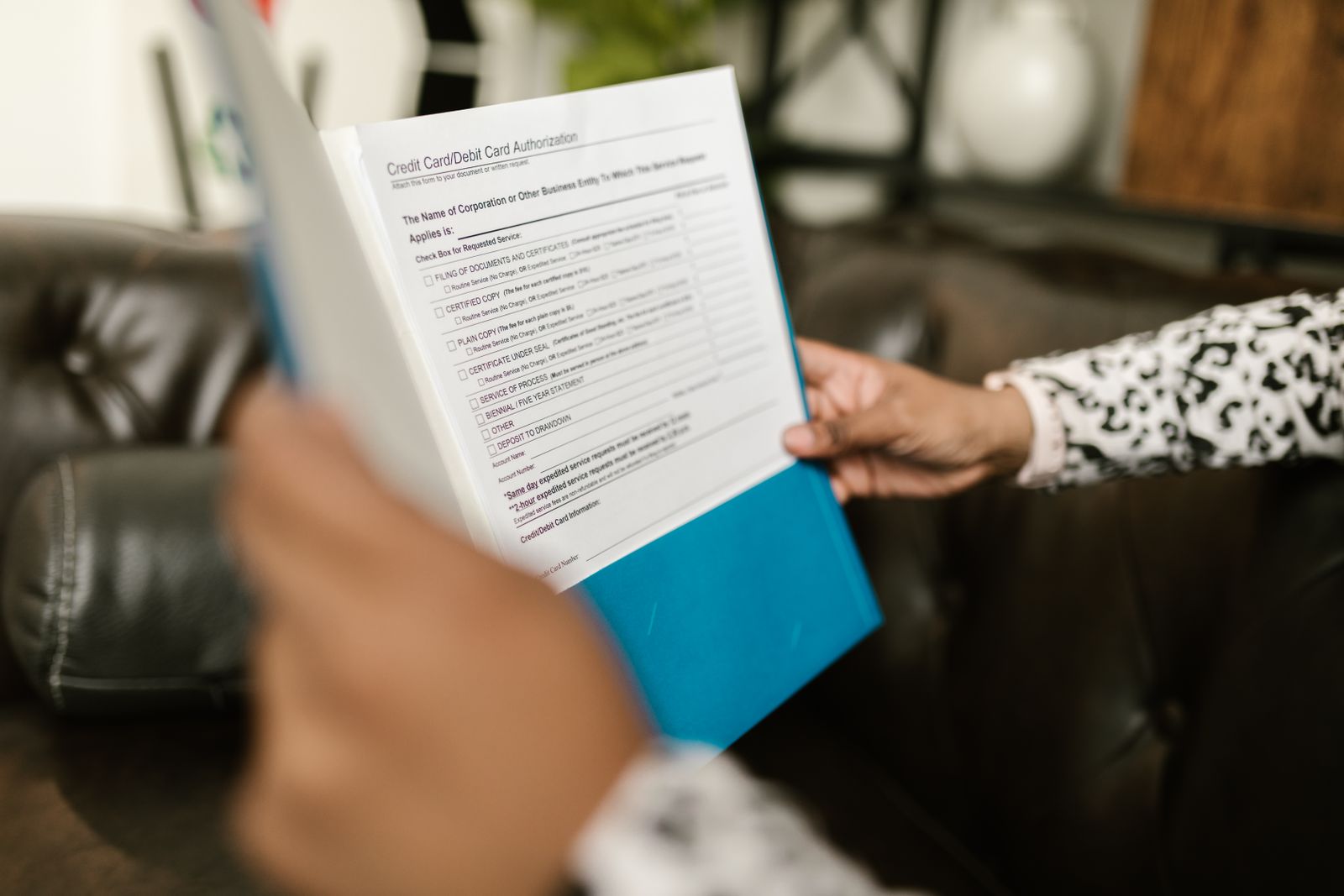 Close-up of a person examining a credit card authorization form inside an office setting