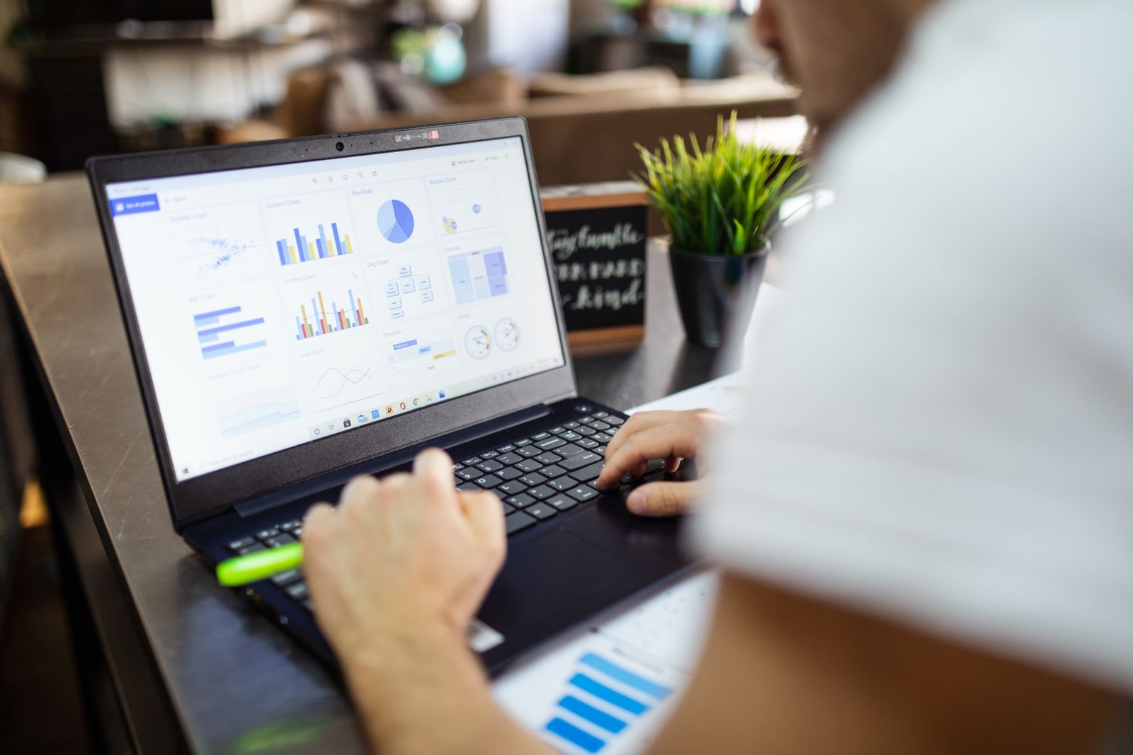 Focused business analysis with charts and graphs on a laptop in a modern office setting
