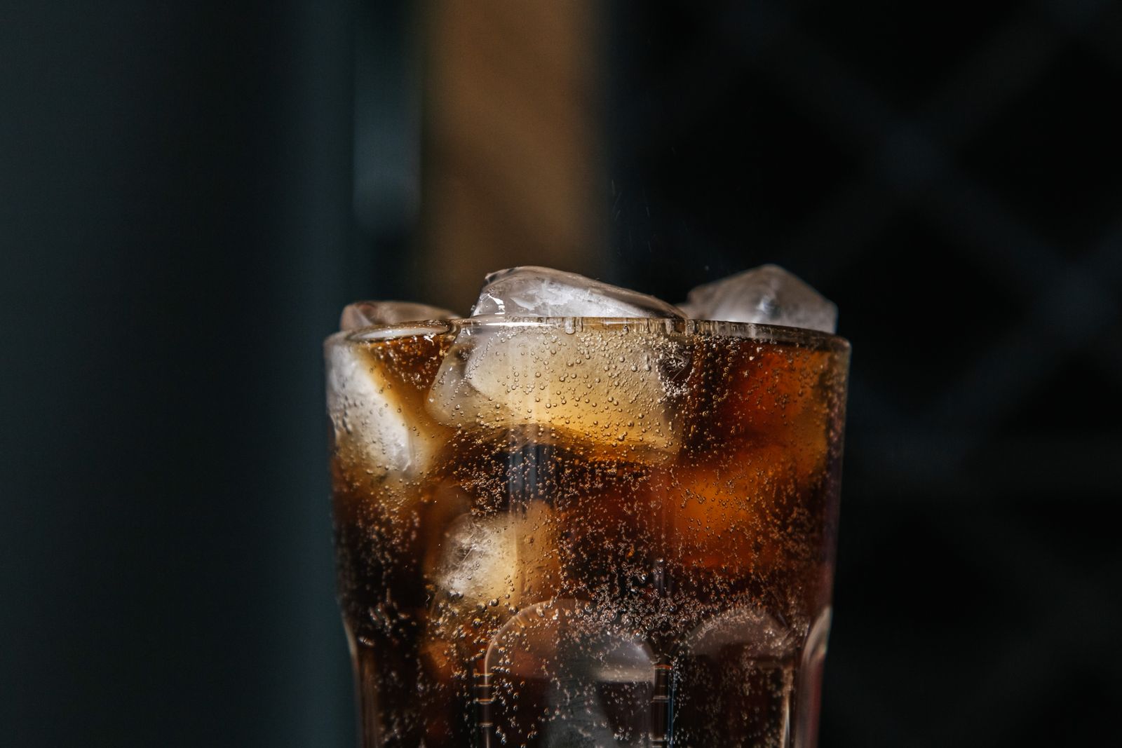 Cooling beverage with fizzy bubbles and ice cubes in a clear glass
