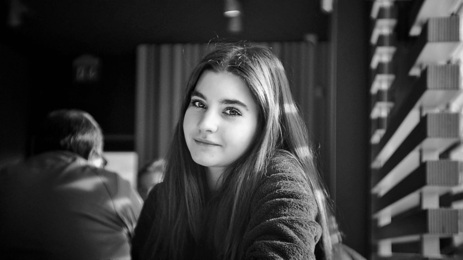 Elegant portrait of a young woman with natural light inside a modern venue